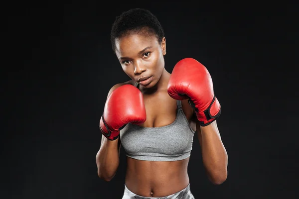 Fitness girl in boxing gloves fighting on black background — Stock Photo, Image