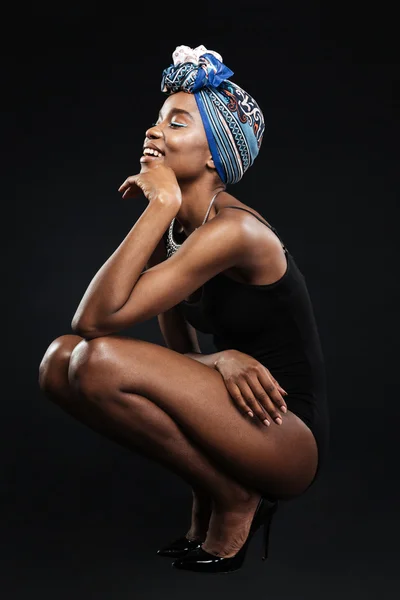 Beautiful smiling african woman in bodysuit posing in studio — Stock Photo, Image