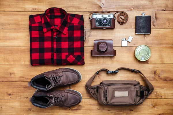 Resekoncept stövlar, skjorta, kamera, tändare, kolv, väska — Stockfoto