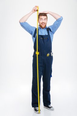 Happy funny young man measuring his body height using tape clipart