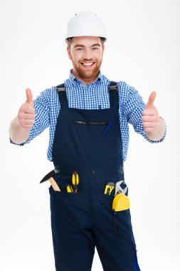 Başparmak gösterilmesini kask içinde mutlu çekici genç builser