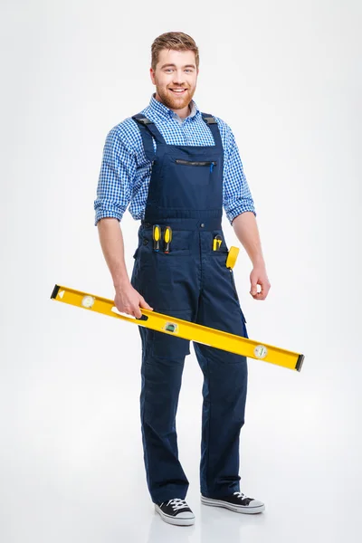 Sorrindo construtor masculino segurando waterpas — Fotografia de Stock