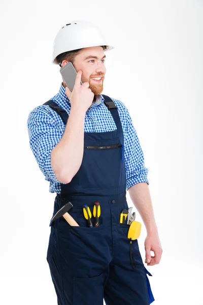 Vrolijke bebaarde jonge bouwer praten op mobiele telefoon — Stockfoto