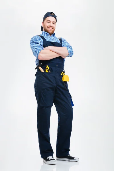 Feliz confiante jovem construtor de pé com os braços cruzados — Fotografia de Stock