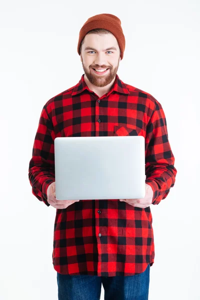 Retrato de cerca de un hombre barbudo guapo sosteniendo el ordenador portátil — Foto de Stock