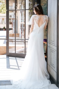 Ayakta ve açık havada poz beyaz elbiseli güzel genç gelin