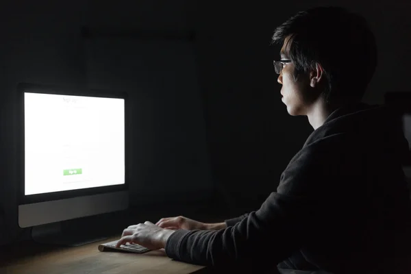 Man zitten en werken met computer in donkere kantoor — Stockfoto