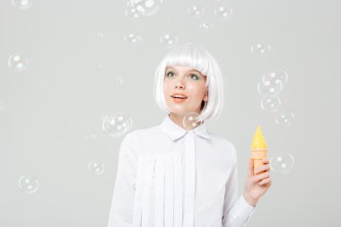 Sabun köpüğü ve holding dondurma bakarak mutlu kadın