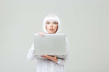 Ayakta ve dizüstü tutan şok genç kadın