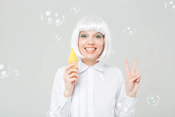 Mujer sonriente mostrando señal de paz y sosteniendo helado falso —  Fotos de Stock