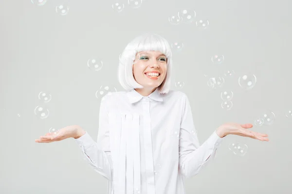 Gelukkige vrouw zeepbellen te genieten en palmen copyspace vasthouden — Stockfoto