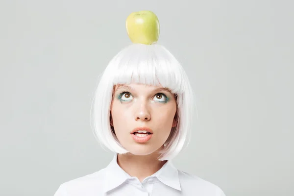 Funny cute young woman with apple on her head — Stock Photo, Image