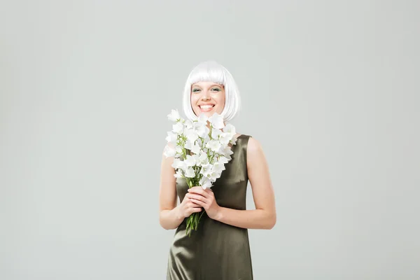Веселая молодая женщина с букетом цветов стоя и смеясь — стоковое фото