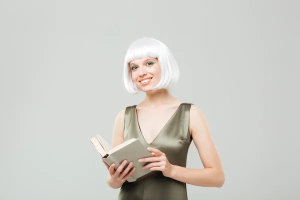 Sorrindo jovem mulher com cabelo loiro lendo um livro — Fotografia de Stock