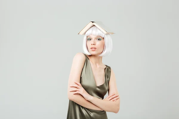 Divertente giovane donna carina con libro sulla sua testa — Foto Stock