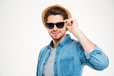 Şapka ve güneş gözlüğü takan kendine güvenen genç adam