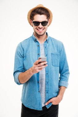 Akıllı telefon kullanarak şapka ve güneş gözlüğü neşeli genç adam