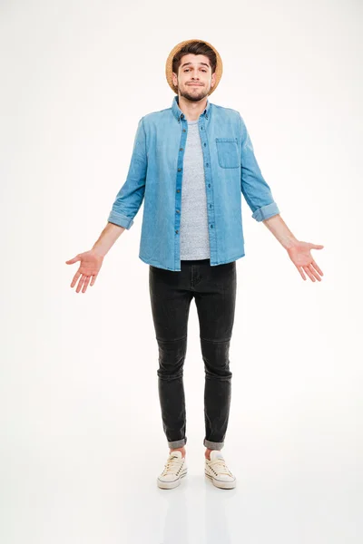 Confuso carino giovane uomo in jeans camicia in piedi e scrollata di spalle — Foto Stock