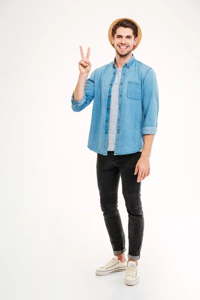 Full length of smiling man standing and showing peace sign — Stock Photo, Image