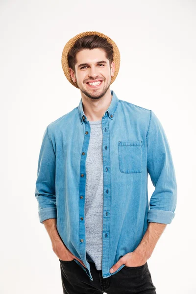 Cheerful young man in hat standing with hands in pockets — Stock Photo, Image