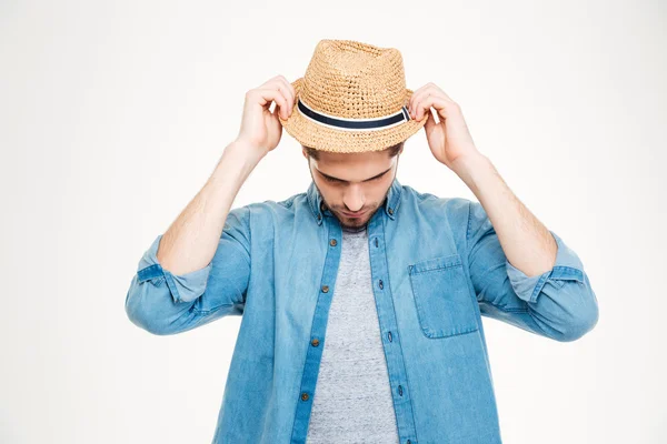 Handsome young man in blue shirt putting on the hat — Stock Photo, Image