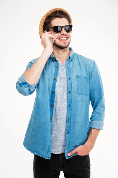 Hombre alegre en sombrero y gafas de sol hablando en el teléfono móvil — Foto de Stock