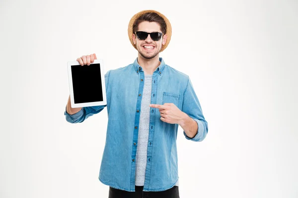 Neşeli genç adam boş ekran tablet tutarak ve işaret — Stok fotoğraf