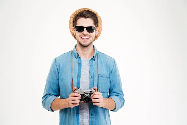 Smiling man in hat and sunglasses using old photo camera — Stock Photo, Image