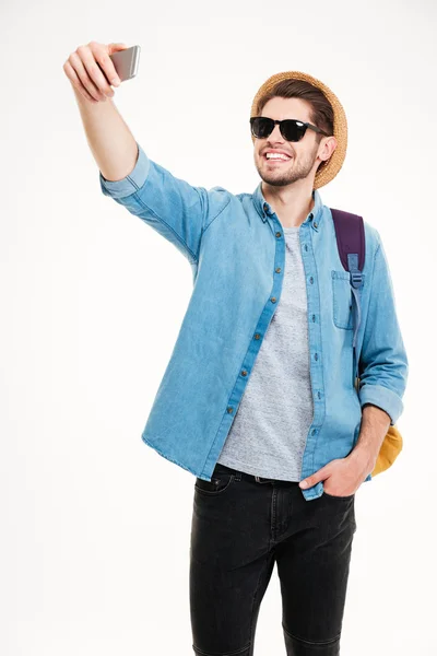 Vrolijke aantrekkelijke man met rugzak nemen selfie met behulp van mobiele telefoon — Stockfoto