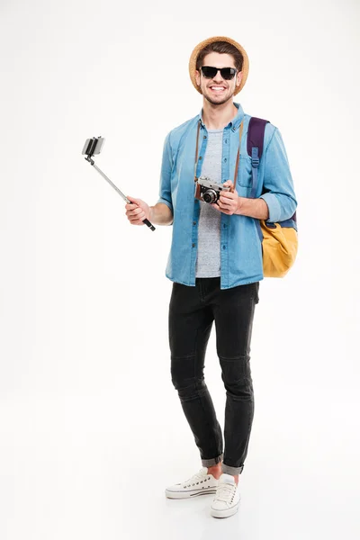 Joyeux jeune touriste, vieil appareil photo et smartphone sur selfie stick — Photo