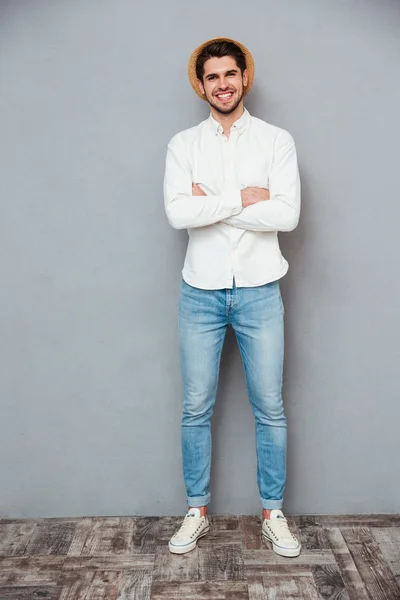 Heureux jeune homme beau chapeau debout avec les bras croisés — Photo