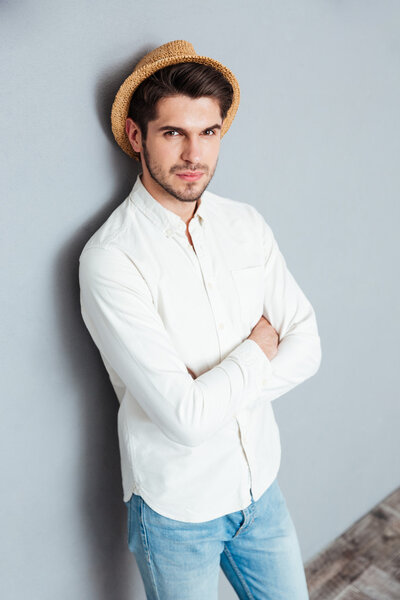 Portrait of a handsome young man standing with arms folded