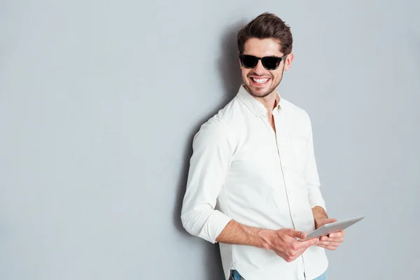 Retrato de um jovem homem feliz segurando tablet computador — Fotografia de Stock