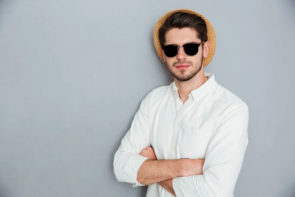 Säker man i hatt och solglasögon står med armarna korsade — Stockfoto