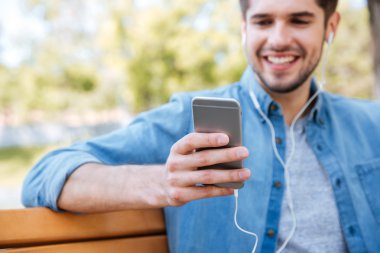 Hareket eden telefon ile oturan bir genç adam Resim kırpılmış