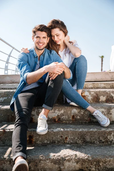 Portrait of a smiling young couple sitting together — Stock Photo, Image