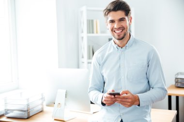 ayakta ve cep telefonu kullanma office gülümseyen iş adamı