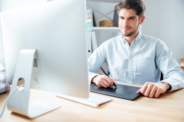 Adam tasarımcı çalışma İşyerinde kullanarak bilgisayar ve grafik tablet