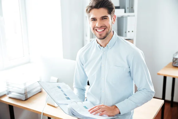 Veselý mladý podnikatel drží složku s dokumenty v office — Stock fotografie