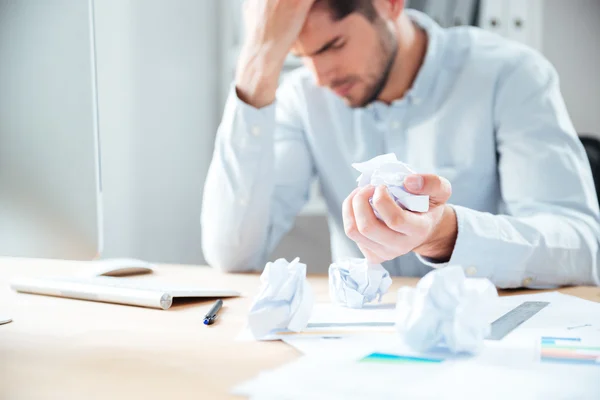 Tired desperate young businessman working and crumpling paper — Stock Photo, Image