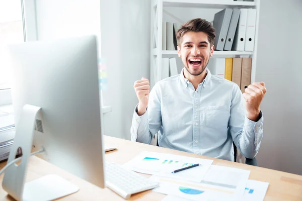 Joyeux jeune homme d'affaires excité célébrant le succès dans le bureau — Photo