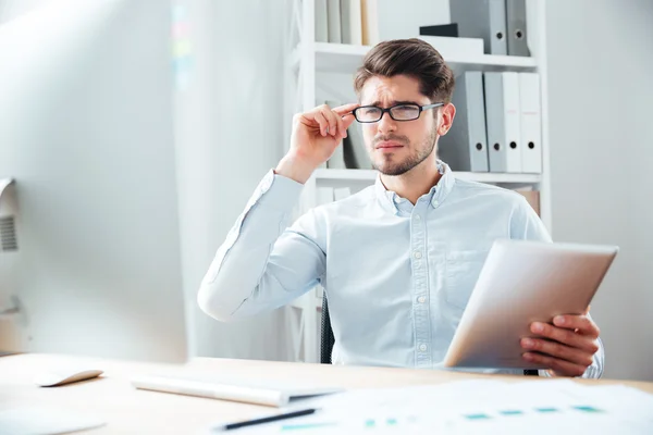 Retrato de primer plano de un empresario pensativo sosteniendo una tableta — Foto de Stock