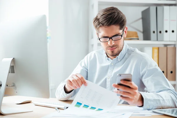 Porträtt av en affärsman som använder mobiltelefon på kontoret — Stockfoto