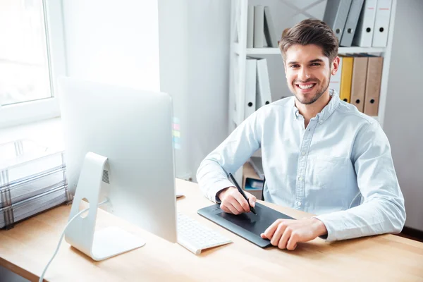 Smiling man designer working and using graphic tablet in office — Stok Foto