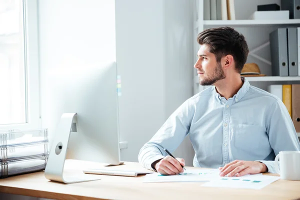 Fundersam affärsman sitter med laptop på kontoret — Stockfoto