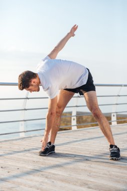 Isınma ve egzersizleri yapıyor ciddi genç adam atlet