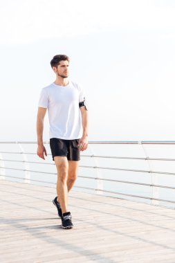 Ahşap Teras deniz kenarında üzerinde yürüyen adam atlet