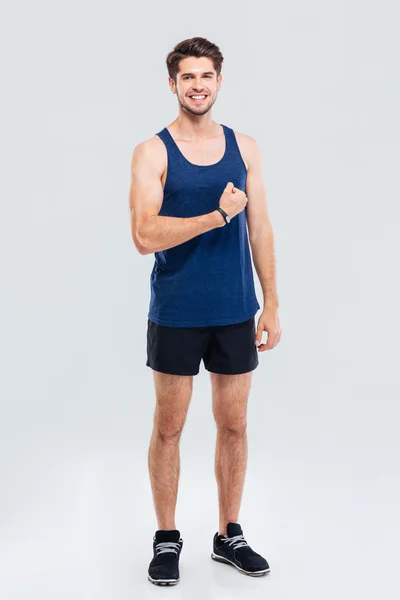 Full length portrait of a smiling man showing his biceps — Stock Photo, Image