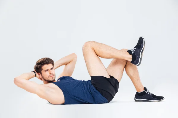 Handsome young man athlete working out and doing crunches — Stock Photo, Image