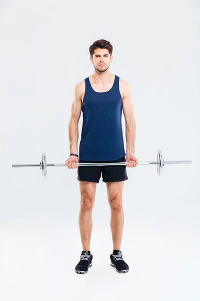 Volle lengte van serieuze man atleet staande en holding barbell — Stockfoto